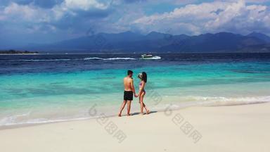 高加索人夫妇会说话的持有手海岸白色<strong>董事</strong>会通过浅水阳光明媚的一天巴厘岛印尼